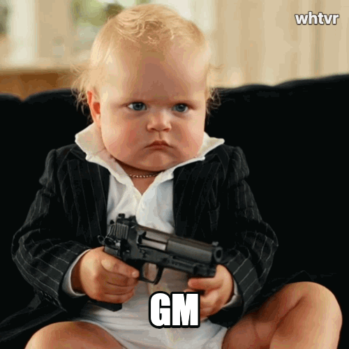 A cute little baby holding a handgun looking like a little gangster