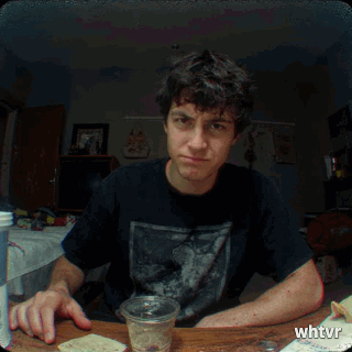 chud guy at his desk giving the camera the middle finger, with attitude, 90s handicam aesthetic, words on screen "fuck you"